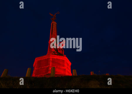 Aberystwyth War Memorial illuminato di rosso da Ceredigion County Council dopo una richiesta del Royal British Legion. Le figure in bronzo sono riportati per rappresentare la vittoria al top per la figura e l'umanità che emergono dagli effetti della guerra per la figura in basso. Progettato dallo scultore Professor Mario Rutelli di Palermo (1859-1941). Credito: Ian Jones/Alamy Live News Foto Stock