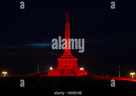 Aberystwyth War Memorial illuminato di rosso da Ceredigion County Council dopo una richiesta del Royal British Legion. Le figure in bronzo sono riportati per rappresentare la vittoria al top per la figura e l'umanità che emergono dagli effetti della guerra per la figura in basso. Progettato dallo scultore Professor Mario Rutelli di Palermo (1859-1941). Credito: Ian Jones/Alamy Live News Foto Stock