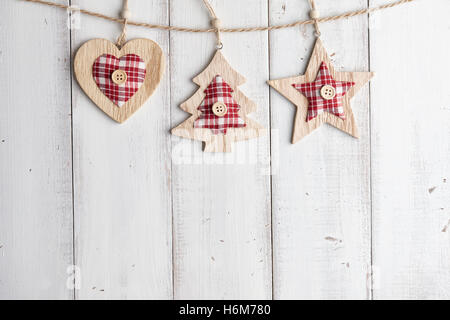 In legno decorazioni di Natale che pende sulla recinzione bianco Foto Stock