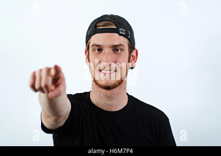 Sorridente Giovani maschi adulti in Dark T-Shirt e Baseball Hat usurato rivolto all'indietro verso il visualizzatore Foto Stock