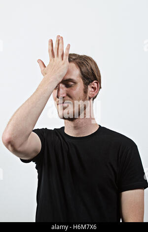 Giovani maschi adulti hanno commesso un grosso errore, indossando il buio T-Shirt Foto Stock