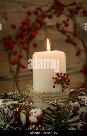 Centrotavola elegante per la tavola del Natale con una candela su una corona di naturale Foto Stock