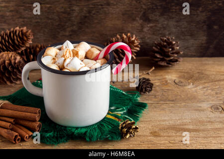 Cioccolata calda con marshmallows, menta piperita candy canes e bastoncini di cannella in metallo vintage mug - in casa calda bevanda di festa Foto Stock