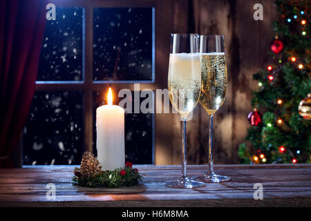 Vista ravvicinata dei due bicchieri con champagne e una candela su colore indietro Foto Stock