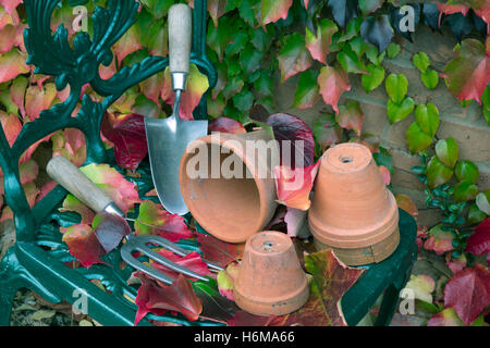 Giardino utensili a mano e terracotta vasi da fiori con caduta foglie di Virginia superriduttore Parthenocissus quinquefolia Foto Stock