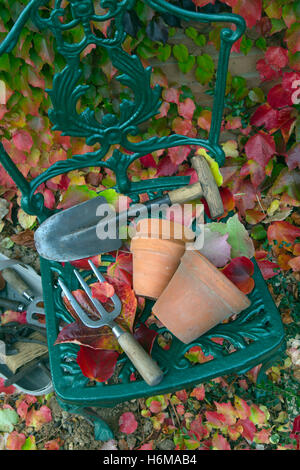 Giardino utensili a mano e terracotta vasi da fiori con caduta foglie di Virginia superriduttore Parthenocissus quinquefolia Foto Stock