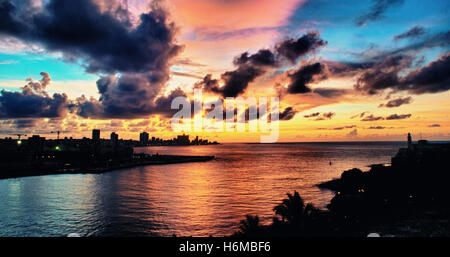 Vista panoramica della baia di Havana e sullo skyline silhouette al tramonto con nuvole drammatico Foto Stock