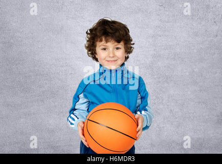 Ragazzo sorridente con sei anni con un canestro guardando la fotocamera Foto Stock