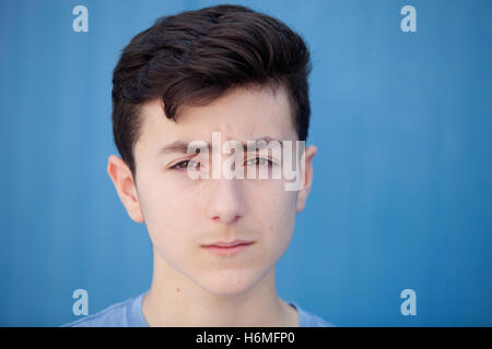 Ritratto di un adolescente ribelle uomo con uno sfondo blu Foto Stock