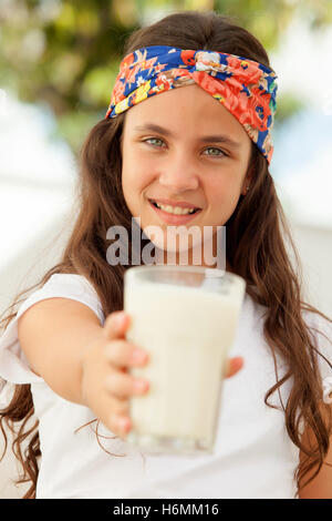 Ragazza adolescente con gli occhi blu e un bicchiere di latte Foto Stock