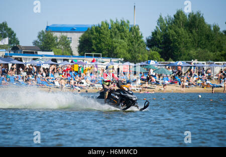 Uomo in motoslitta va veloce sull'acqua in estate Foto Stock