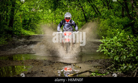 Enduro moto nel fango con un grande splash Foto Stock