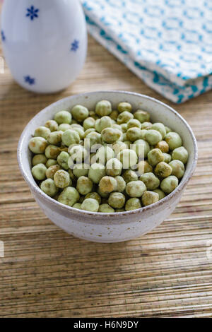 Wasabi piselli un snack croccante fatto con arrosti di piselli verdi rivestita con wasabi condimento in un giapponese vaso in ceramica Foto Stock