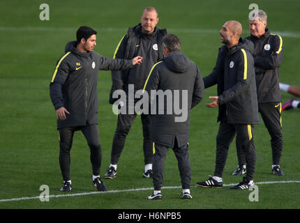 Manchester City manager Pep Guardiola e co-assistant coach di Mikel ARTETA (sinistra) parlare durante una sessione di formazione presso il City Football Academy, Manchester. Foto Stock