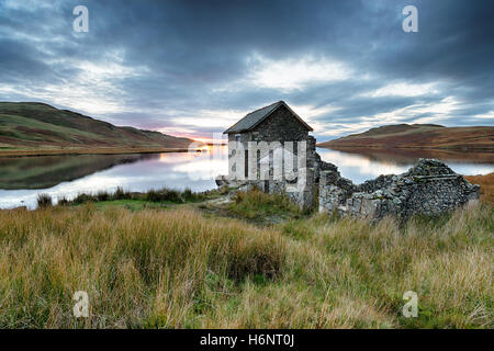 Una bella antica pietra boathouse sulle rive del Devoke acqua sul Parco nazionale del Lake District in Cumbria Foto Stock