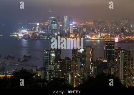 I grattacieli illuminati e altri edifici sull isola di Hong Kong e Kowloon in Hong Kong, Cina. Visto dal Braemar Hill. Foto Stock