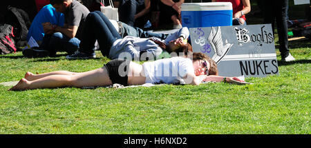 Un manifestante prende un pisolino in erba durante una manifestazione di protesta contro il collegio annuale escursioni lezioni durante il mese di marzo in marzo rally. Foto Stock