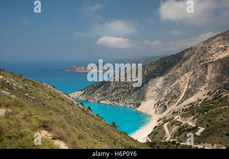 Vista della spiaggia di Myrtos, sull'isola greca di Cefalonia, con il villaggio di Assos a distanza Foto Stock