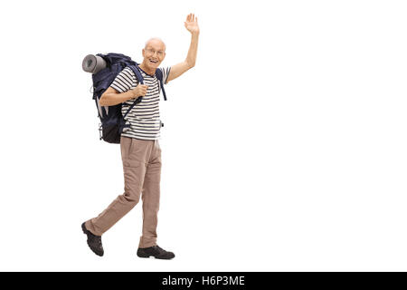 A piena lunghezza Ritratto di un anziano escursionista a piedi e agitando la fotocamera a isolati su sfondo bianco Foto Stock