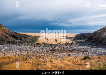 Tempesta lontano oltre il North Devon Coast visto dalla Spiaggia Pobbles, Three Cliffs Bay, Gower, South Wales, Regno Unito. Foto Stock