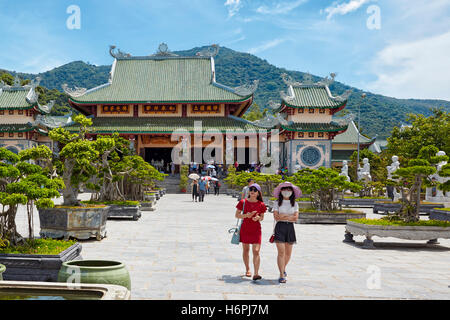 Due giovani donne a camminare nel giardino Bonsai a Linh Ung Pagoda. Da Nang, Vietnam. Foto Stock