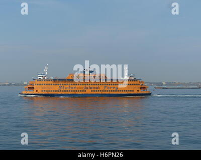 La Staten Island Ferry si inclina a destra come folla turistica dritta per fotografare la Statua della Libertà Foto Stock