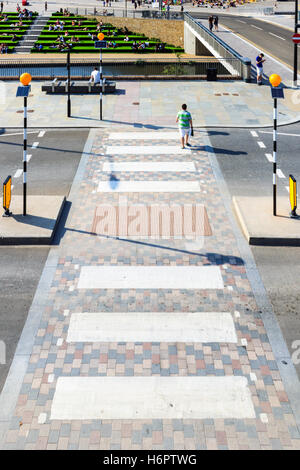 Attraversamento pedonale sulle merci in modo Piazza Granaio, King's Cross, Londra, Regno Unito, il manto erboso sintetico coperto a fasi di Granaio Square al di là di Regent's Canal Foto Stock