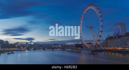 La mitica London Eye ruota panoramica Ferris su un estate blu di illuminazione serale lungo il fiume e supervisionare le barche. Foto Stock