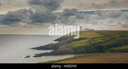 La cucina capo faro può essere visto nella distanza che si eleva al di sopra dell'orizzonte sul promontorio in West Cork, Irlanda. Foto Stock