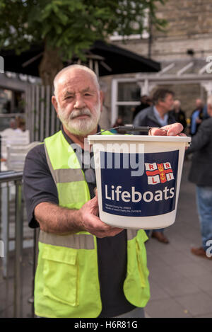 Un volontario di carità collector raccolta fondi per il RNLI. Foto Stock