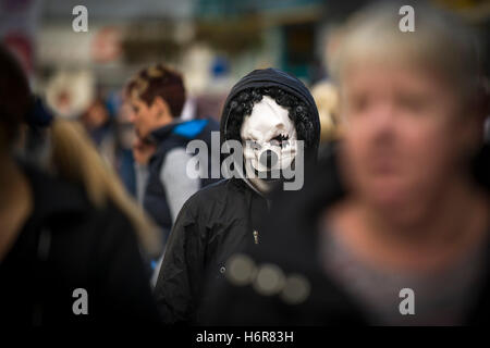 Un adolescente che indossa una maschera da clown durante le celebrazioni di Halloween. Foto Stock