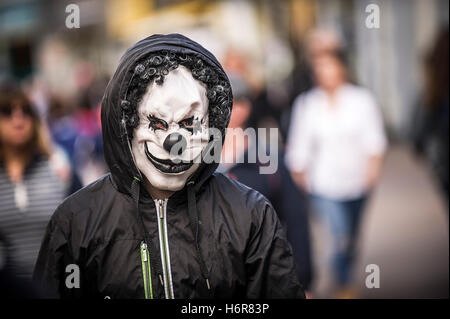 Un adolescente che indossa una maschera da clown durante le celebrazioni di Halloween. Foto Stock