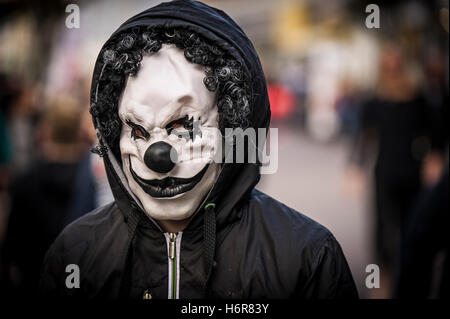 Un adolescente che indossa una maschera da clown durante le celebrazioni di Halloween. Foto Stock