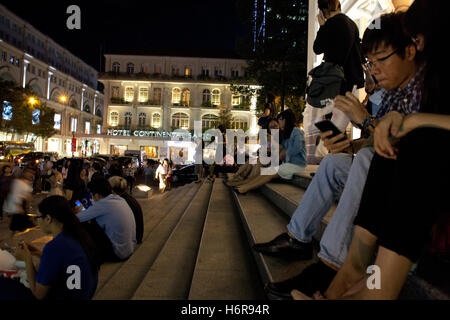 I frequentatori di concerti sulla Opera House passi davanti a Hotel Continental nel centro di Ho Chi Minh city, forrmerly a Saigon, Vietnam Foto Stock