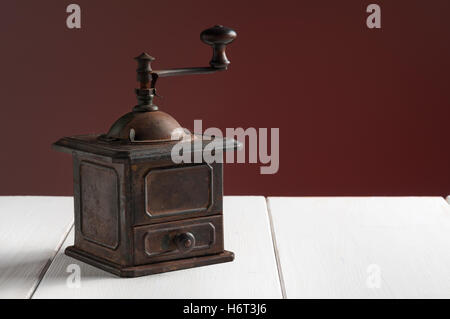 Antica macina caffè bianco su una superficie di legno Foto Stock