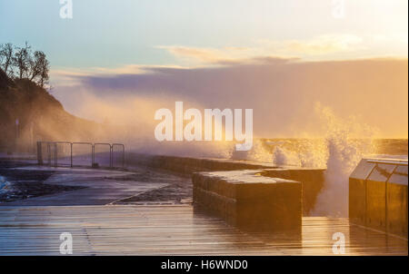 Onde la frantumazione con vigore il Mornington molo frangiflutti e al tramonto. Melbourne, Australia Foto Stock