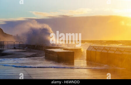 Onde la frantumazione con vigore il Mornington molo frangiflutti e al tramonto. Melbourne, Australia Foto Stock