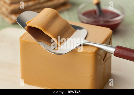 Pezzo di flotemysost norvegese di formaggio e un'affettatrice Foto Stock