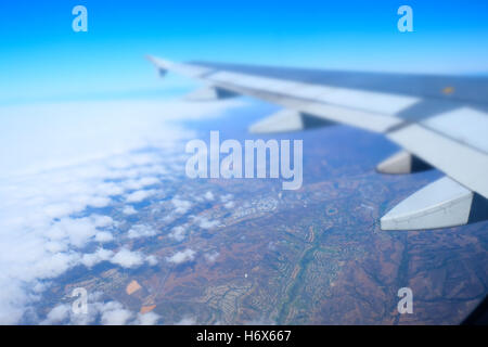 Volo aereo su una vasta sezione di dense nubi che sfumano in un cielo terso Foto Stock