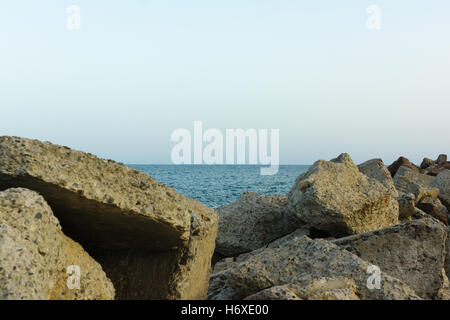 Grandi pietre sdraiato sulla spiaggia alla luce del sole di setting Foto Stock