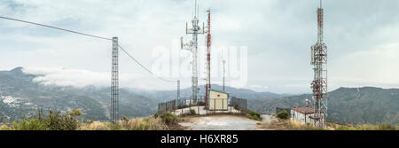 Telecomunicazioni (GSM) torri con antenne TV sulla montagna Foto Stock