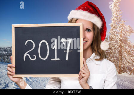 Ragazza carina in xmas hat con lavagna Foto Stock