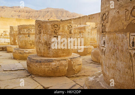 Il rovinato collonade con i rilievi della sacra cobras nel tempio mortuario di Ramesse III a Medinet Habu, Luxor, Egitto. Foto Stock