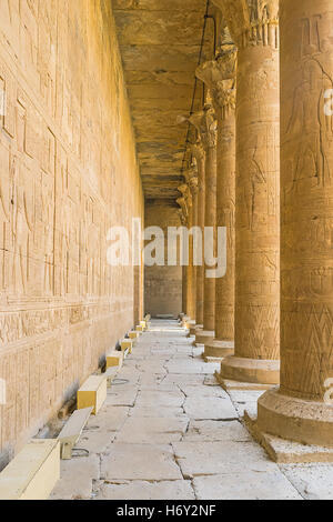 I muri di pietra e numerose colonne nel Tempio di Horus decorata dagli antichi rilievi con divinità egizie e geroglifici, Edfu Foto Stock