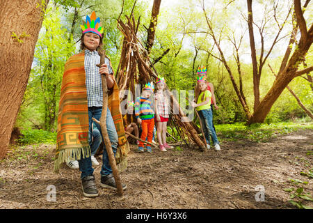 Carino ragazzo giocando Red capo indiano nella foresta Foto Stock