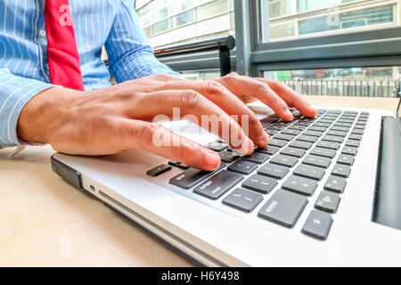 Un maschio nero mani usando un computer portatile Foto Stock