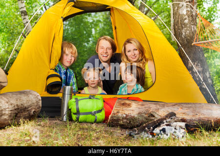 Felice famiglia giovane rilassante all'interno della tenda nel bosco Foto Stock