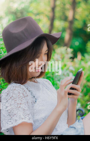 Ragazza con lo smartphone in posizione di parcheggio Foto Stock