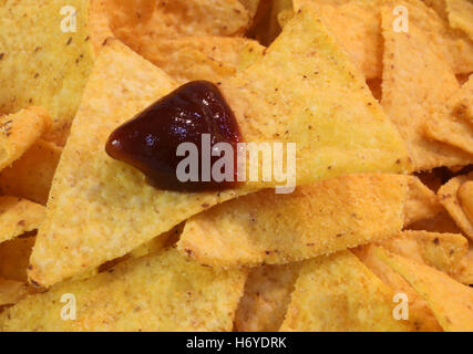 Sullo sfondo di un giallo fragrante tortilla chips con salsa calda dip Foto Stock