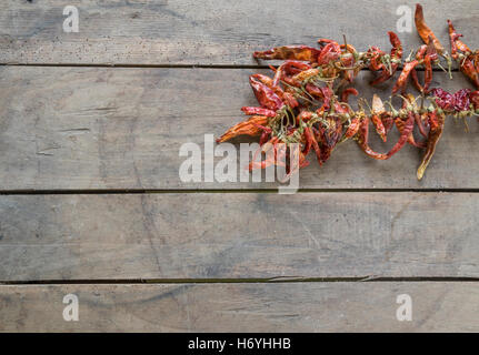 Mazzetto di red hot chili, carte su sfondo di legno. Foto Stock